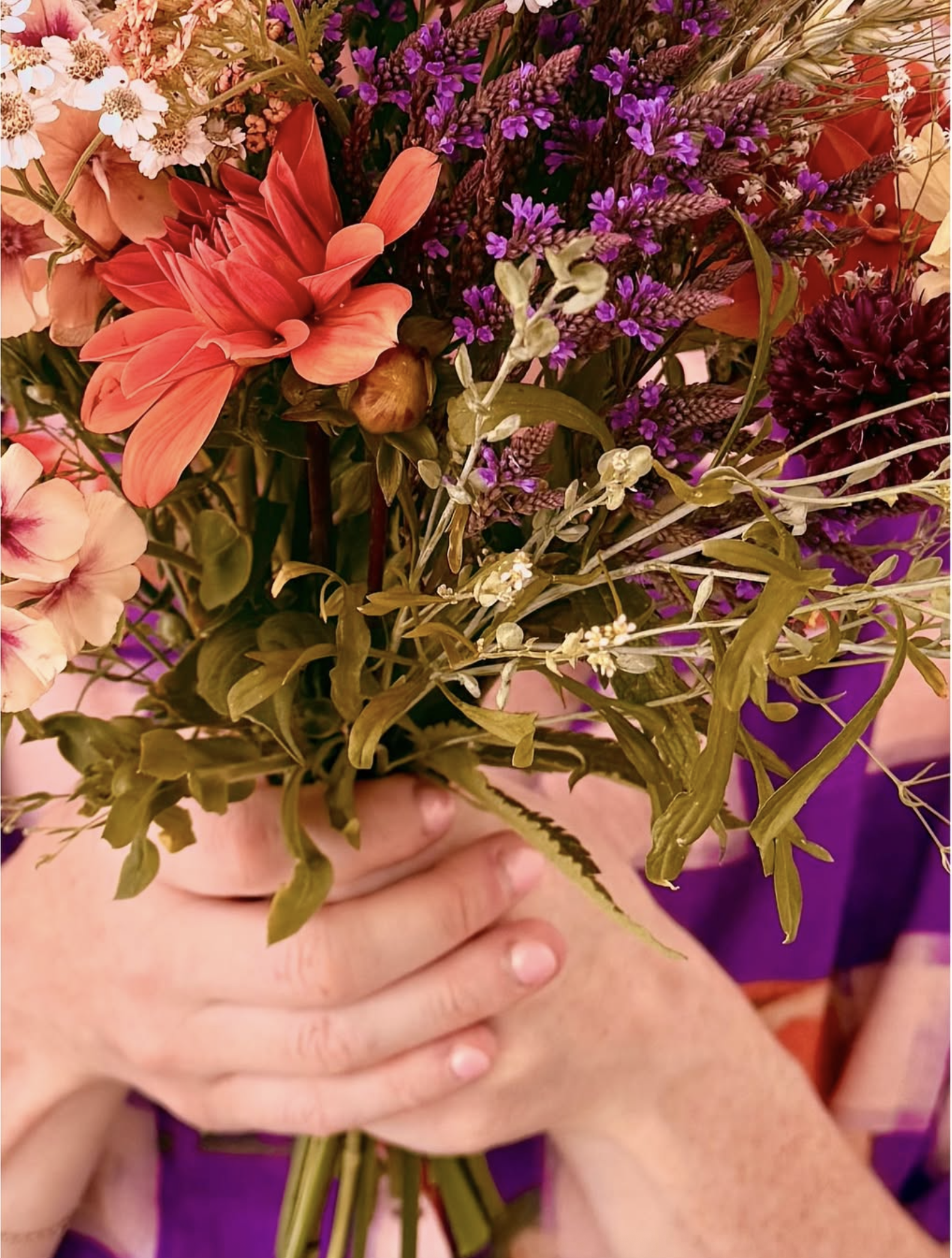 Hands holding a bunch of beautiful flowers.